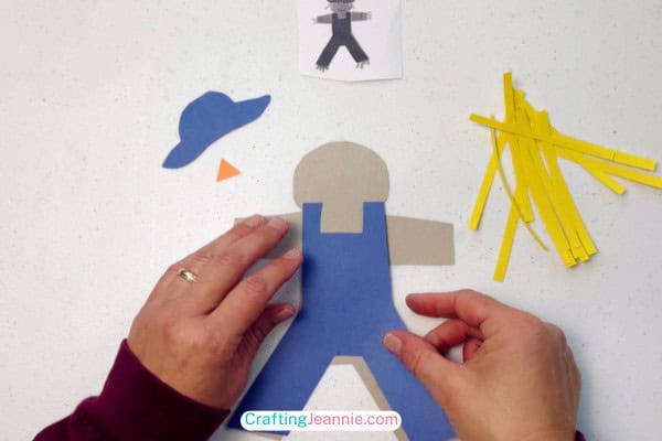 glue the overalls onto the paper scarecrow