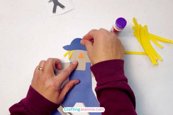 glue the hat onto the preschool scarecrow