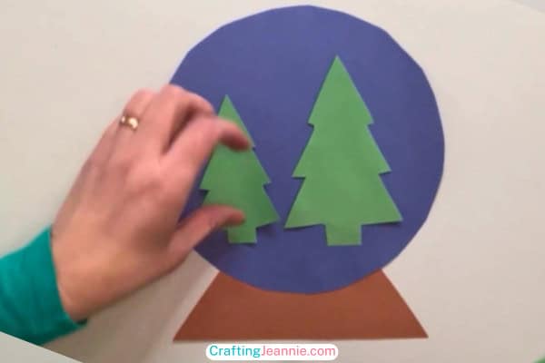 step 2 glue the trees onto the paper snow globe